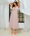 Women’s dusty pink cocktail dress with gold buckle cutouts.
