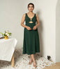 Women’s green midi dress with gold buckle cutouts.

